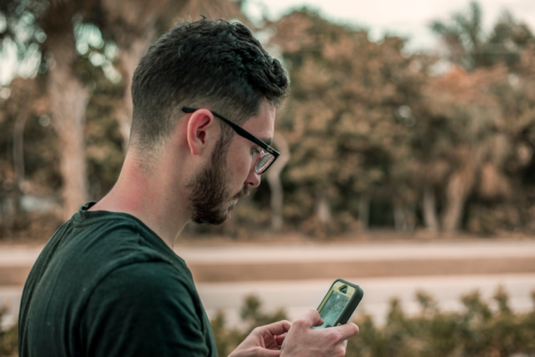 man looking down on his phone — Foto por Jacob Townsend na Unsplash