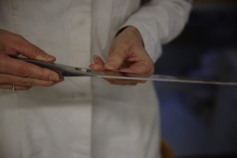 a close up of a person cutting something with a pair of scissors — Foto por Sternsteiger Germany na Unsplash