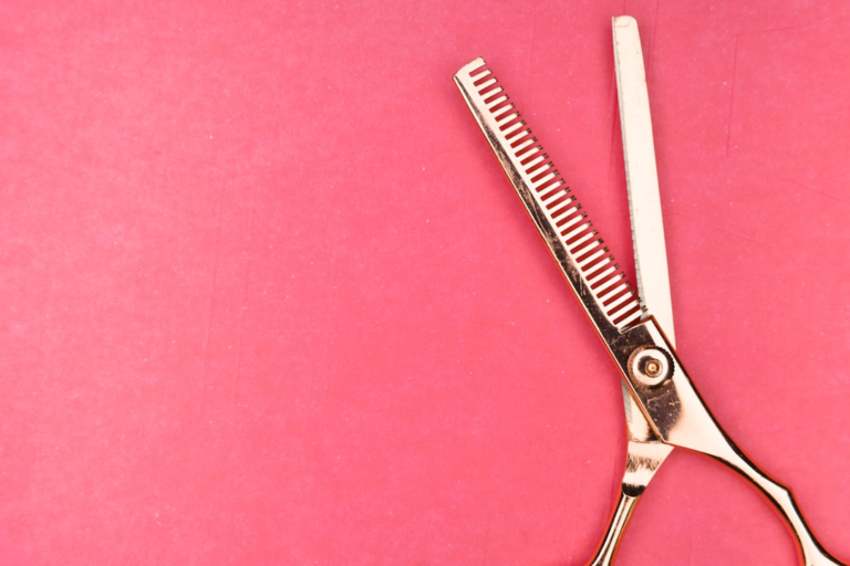 silver scissors on red textile — Foto por Markus Winkler na Unsplash